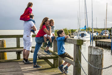 Familie steht auf einer Seebrücke und schaut auf die Aussicht, Ahrenshoop, Mecklenburg-Vorpommern, Deutschland - EGBF00426