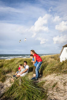 Familie in einer Stranddüne mit Blick auf die Aussicht, Darss, Mecklenburg-Vorpommern, Deutschland - EGBF00435