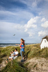 Familie in einer Stranddüne mit Blick auf die Aussicht, Darss, Mecklenburg-Vorpommern, Deutschland - EGBF00436