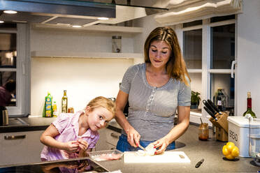 Mutter und Tochter bereiten Essen in der Küche vor - EGBF00441