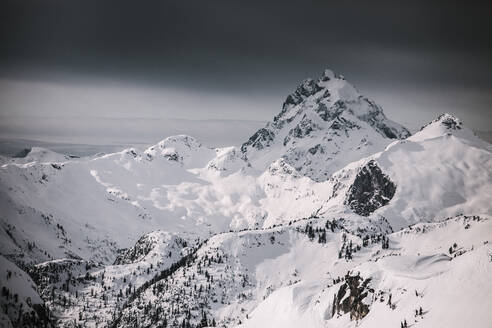 Ein Wintersturm nähert sich einem schneebedeckten Gipfel. - CAVF65935