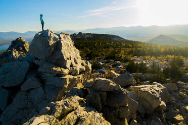 Hiker standing on rock formation against sky - CAVF66117