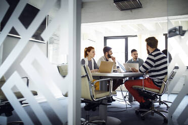 Business colleagues discussing in board room meeting - CAVF66120