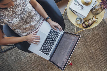 High angle view of businesswoman using laptop computer while sitting on chair at home office - CAVF66161