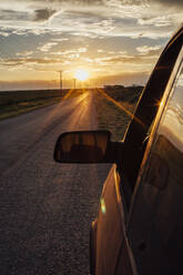 Nahaufnahme des Rückspiegels eines Autos gegen den Himmel bei Sonnenuntergang - CAVF66214