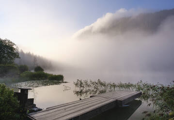 Germany, Bavaria, Mittenwald, Jetty on lakeshore of Ferchensee at misty sunrise - SIEF09222