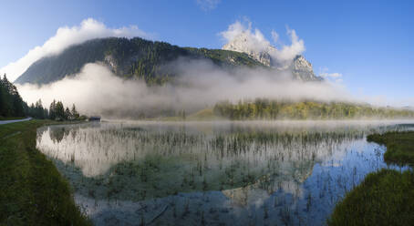 Deutschland, Bayern, Mittenwald, Dichter Nebel schwebt über dem Ferchensee mit Wettersteinspitzen im Hintergrund - SIEF09230