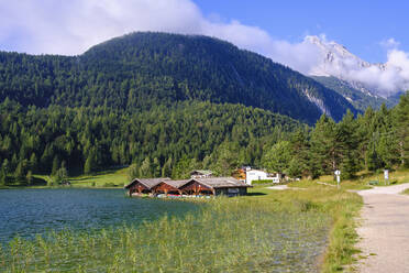 Deutschland, Bayern, Mittenwald, Bootshäuser am Seeufer mit bewaldetem Wettersteingebirge im Hintergrund - SIEF09241