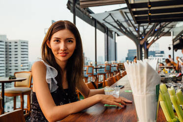 Hübsche thailändische Frau in einer Rooftop-Bar - CAVF66258