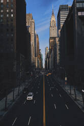 High angle view of cars moving on city street amidst buildings - CAVF66429