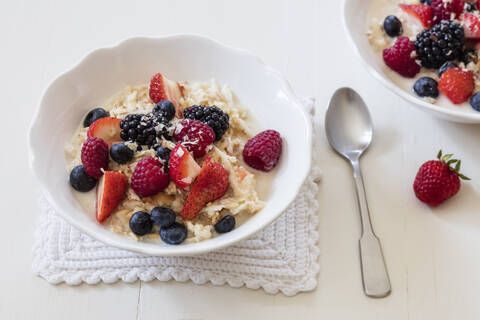 Bowls of fresh vegan muesli with various berries, currants and almond milk stock photo