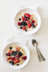 Bowls of fresh vegan muesli with various berries, currants and almond milk - EVGF03522