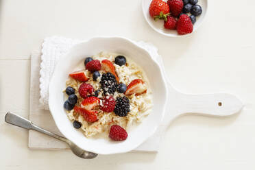 Bowl of fresh vegan muesli with various berries, currants and almond milk - EVGF03523