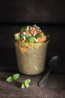 Veganer Pudding im Glas mit Chia, Mandelmilch, Kaki, Kiwi, Papaya, Passionsfrucht und Mandeln - EVGF03528