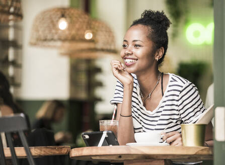 Porträt einer glücklichen jungen Frau in einem Cafe - UUF19222