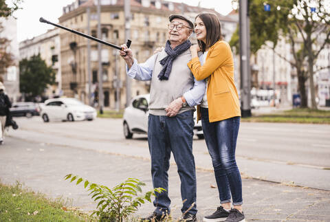 Älterer Mann und erwachsene Enkelin erkunden die Stadt, lizenzfreies Stockfoto