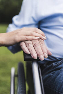 Young woman touching senior man's hand, close-up - UUF19321