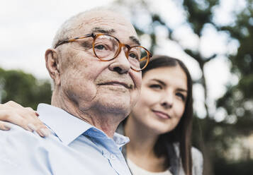 Porträt eines selbstbewussten älteren Mannes mit Enkelin im Hintergrund - UUF19323