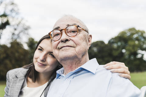 Porträt eines selbstbewussten älteren Mannes mit seiner Enkelin in einem Park, lizenzfreies Stockfoto