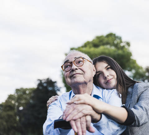 Portrait of senior man and his granddaughter in a park stock photo