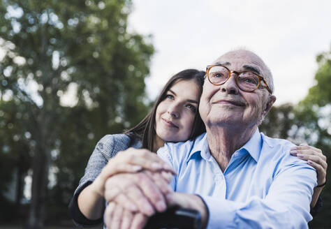 Portrait of senior man and his granddaughter in a park - UUF19339