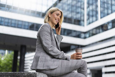 Happy young businesswoman on the phone in the city - DIGF08652