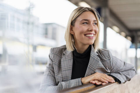 Happy young businesswoman at the train station looking around stock photo