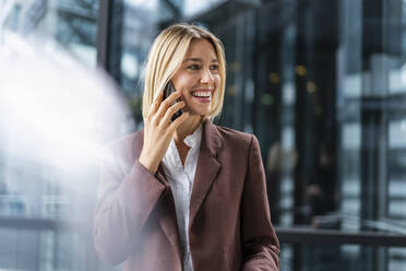 Happy young businesswoman on the phone in the city - DIGF08682