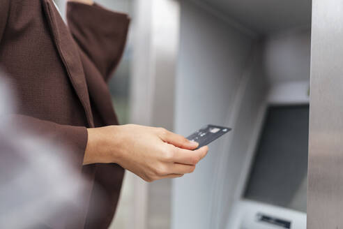 Close-up of businesswoman withdrawing money at an ATM - DIGF08706