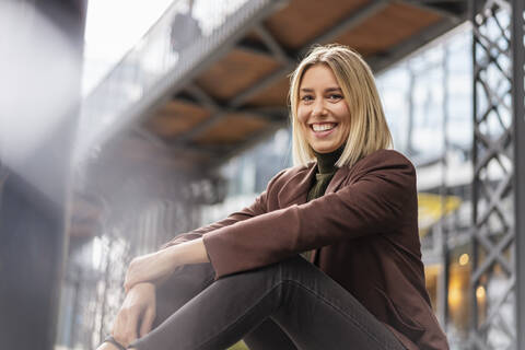 Porträt einer glücklichen jungen Geschäftsfrau, die eine Pause in der Stadt macht, lizenzfreies Stockfoto