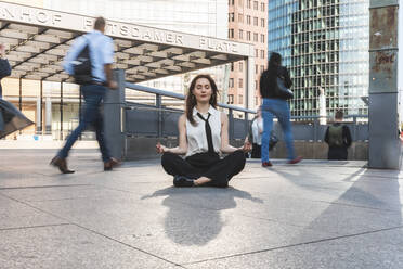 Junge Geschäftsfrau übt Yoga in der Stadt zur Hauptverkehrszeit, Berlin, Deutschland - WPEF02180