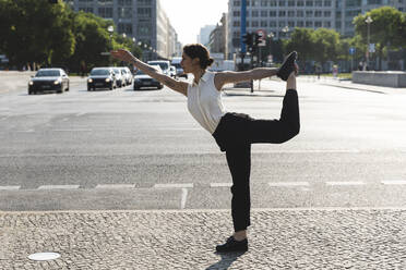 Junge Geschäftsfrau, die in der Stadt Yoga praktiziert, Berlin, Deutschland - WPEF02188