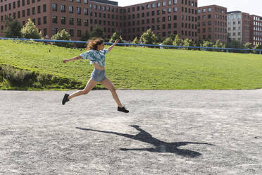Junge Frau springt und läuft in der Stadt im Sommer - WPEF02200