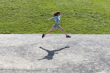 Junge Frau springt und läuft im Sommer im Freien - WPEF02201