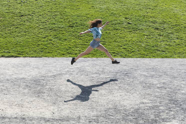 Young woman jumping and running outdoors in summer - WPEF02201