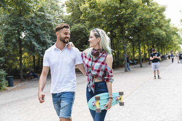 Glückliches junges Paar beim Spaziergang in einem Park - WPEF02219