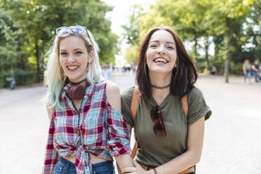 Portrait of two happy friends together in a park - WPEF02223