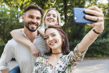 Gruppe von drei Freunden nimmt Selfie mit Smartphone - WPEF02232