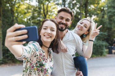 Gruppe von drei Freunden nimmt Selfie mit Smartphone - WPEF02233