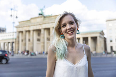 Porträt einer lächelnden jungen Frau vor dem Brandenburger Tor, Berlin, Deutschland - WPEF02235