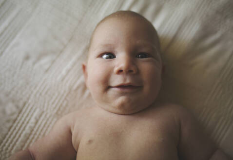 Hohe Winkel Porträt von Baby-Junge auf dem Bett zu Hause liegen - CAVF66713