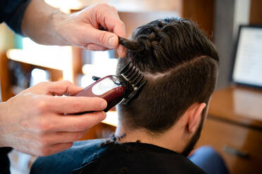 Friseurin rasiert die Haare eines Kunden im Friseursalon - CUF52889