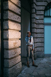 Stilvoller Mann mit Mobiltelefon vor einem historischen Gebäude, Mailand, Italien - CUF53030