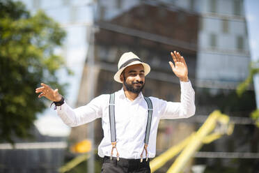 Man with panama hat dancing in city - CUF53094