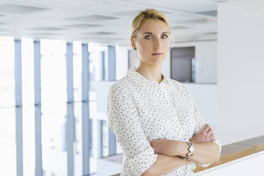 Businesswoman taking break in office corridor - CUF53110
