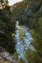 Blick von oben auf einen fließenden Fluss inmitten von Bergen - CAVF66806