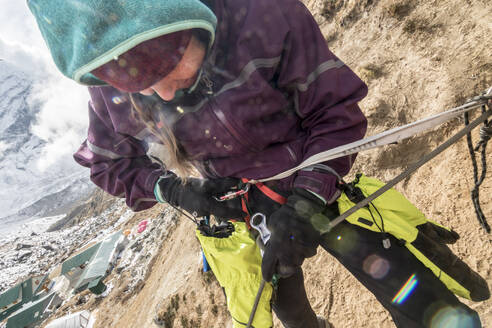 A woman climber engages her figure 8 rappel device - CAVF66876