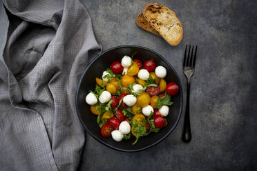 Overhead view of salad with arugula, mozzarella, cherry tomatoes and basil - LVF08407