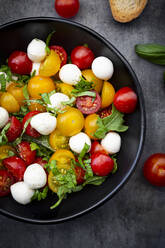 Overhead view of salad with arugula, mozzarella, cherry tomatoes and basil - LVF08409