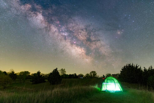 Zelten im Freien in einem Zelt mit Lampenbeleuchtung unter Sternen und der Milchstraße - CAVF66963